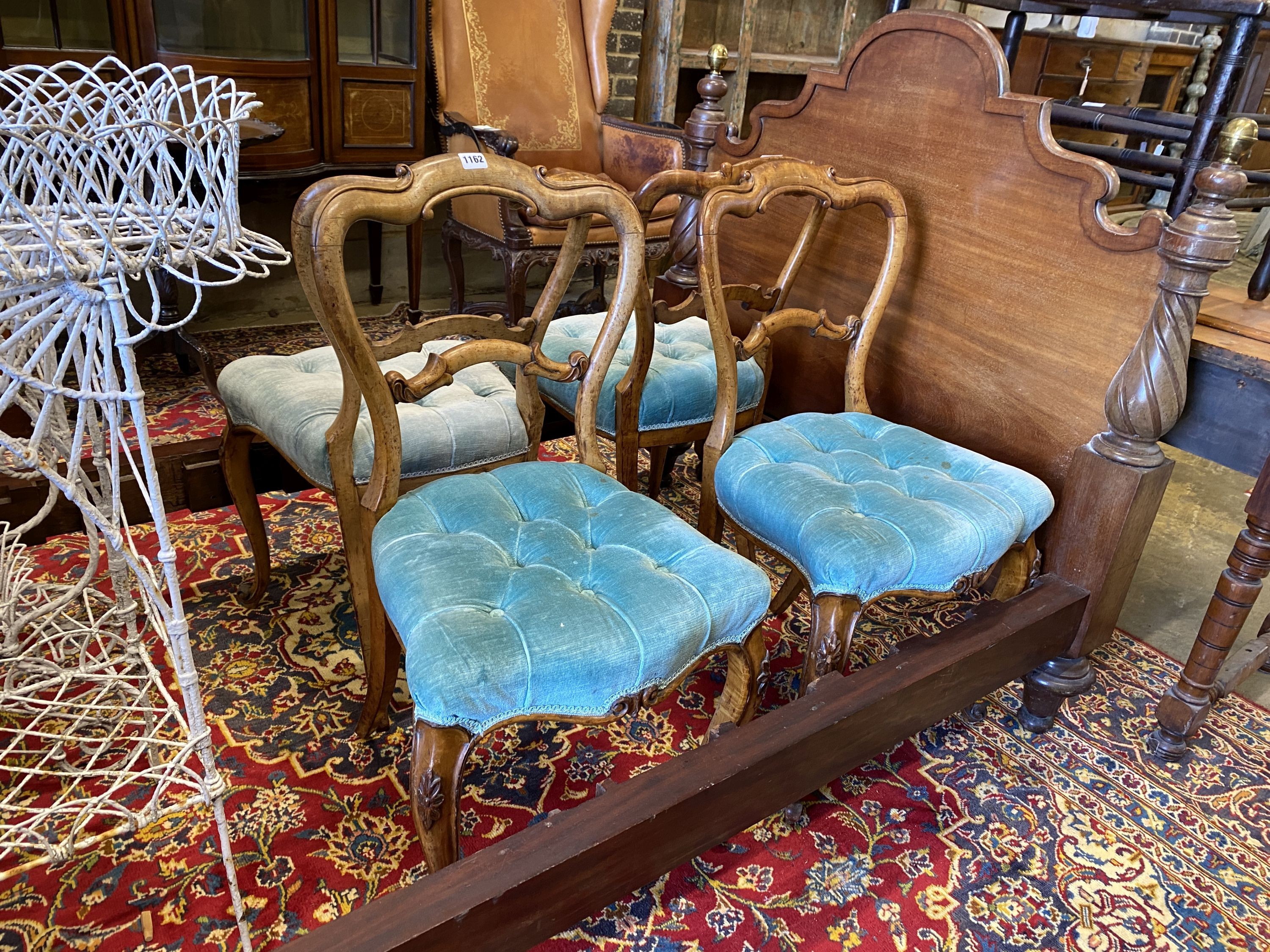 A set of four Victorian walnut balloon back upholstered dining chairs